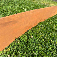 Close up of smooth-look corten steel edging and rusted metal garden edging installed as a lawn divider.